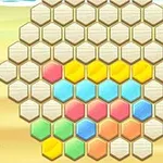 Hatszögletű rács színes hexagonális elemekkel, beleértve a sárga, kék, rózsaszín és zöld darabokat, egy homokos háttérrel