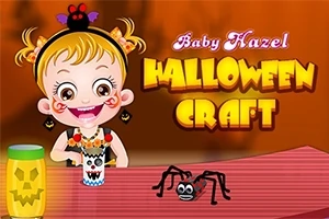 Egy rajzfilmfigurájú kislány mosolyog egy halloween témájú kézműves asztalnál, mellette tök és pókkal