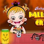 Egy rajzfilmfigurájú kislány mosolyog egy halloween témájú kézműves asztalnál, mellette tök és pókkal