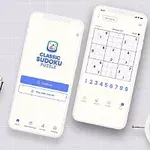 Két okostelefon egy asztalon, az egyik egy sudoku alkalmazás nyitóképernyőjét mutatja, a másik egy sudoku rejtvényt, körülöttük irodai eszközök és egy kisméretű ébresztőóra
