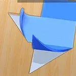 Képen egy fa asztalon kék és narancssárga színű, egymásra hajtogatott lapok láthatók, amik geometrikus formát alkotnak