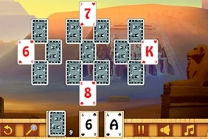 Kártyalapok egyiptomi témájú háttér előtt, néhány lap felfordítva, számokkal és betűkkel
