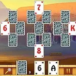 Kártyalapok egyiptomi témájú háttér előtt, néhány lap felfordítva, számokkal és betűkkel