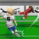 Egy focista fehér mezben rúgja a labdát a kapu felé, miközben a kapus piros mezben vetődik a labda irányába