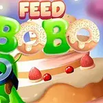 Zöld, szemüveges karakter egy süteményekkel teli háttér előtt, Feed Bobo szöveggel