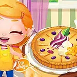 Egy rajzfilmfigura sárga kötényben mosolyog egy gyümölcsökkel és krémmel díszített pite mellett, háttérben pedig egy csíkos tapétás szoba látható