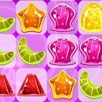 Színes zselés édességek geometriai formákba rendezve egy lila háttéren