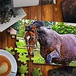 Puzzle, amelyen egy barna ló látható zöld növényzet előtt, fából készült asztalra rakva, szétszórt puzzle darabokkal és egy csésze kávéval a sarokban
