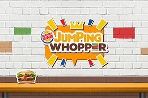Fehér téglafal Burger King logóval és Jumping Whopper felirattal, alatta egy asztalon Whopper szendviccsel