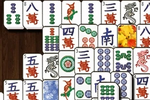 Mahjong játék lapjai különböző mintákkal és szimbólumokkal egy fa mintás háttér előtt