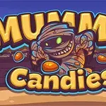 Egy mosolygó, pólyába tekert múmia színes cukorkákkal a sivatagi háttér előtt, a MUMMY Candies felirat alatt