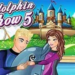 Egy szőke férfi és egy barna hajú nő egy delfint ölel a vidámpark hátterével