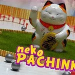 Egy fehér maneki-neko macska figura piros nyaklánccal és arany táblával, zöld gyepen ül, körülötte kis fémgolyók és fa kerítés, alul pedig a neko PACHINKO felirat látható