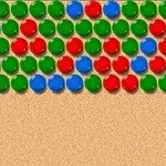 Színes piros, zöld és kék golyók sűrűn egymás mellett egy homokszínű háttéren