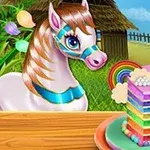 Egy fehér póni nézi a szivárvány színű süteményt egy kerti asztalon, háttérben zöld mezővel és kerítéssel