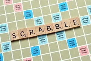 A kép egy scrabble táblát mutat, amelyen a SCRABBLE szó van kirakva fa betűlapkákkal