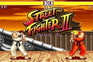 Street Fighter II Két harcos egymással szemben áll egy fa padlón, háttérben ágyúval és narancssárga égbolttal, középen a Street Fighter II logóval