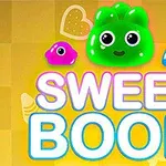 Színes cukorkafigurák, köztük egy zöld, egy rózsaszín és egy kék, a SWEET BOOM felirat felett, sárga háttéren