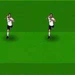 Két futballista fehér mezben fut, és szemben egy sárga-fekete mezes játékos passzra készül a zöld pályán